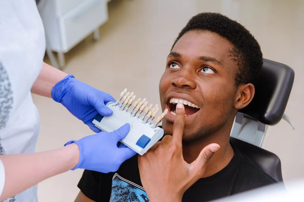 Dentist performing dental shade matching for a patient in a clinic.